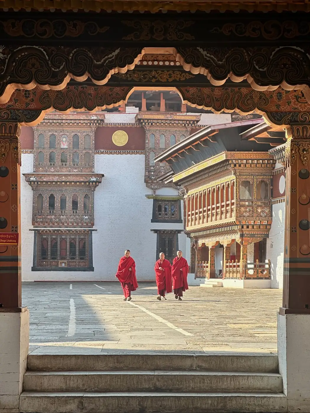 Monks walking through Wangduephodrang Dzong courtyard